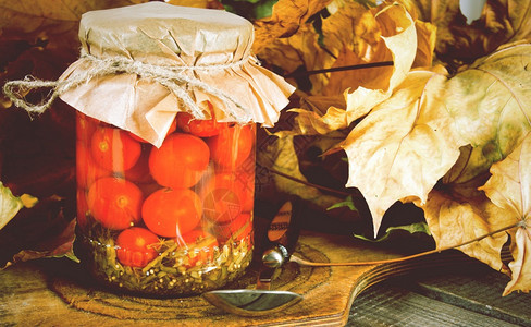 秋天概念在木板上的玻璃罐中保存食物西红柿在玻璃罐中保存食物图片