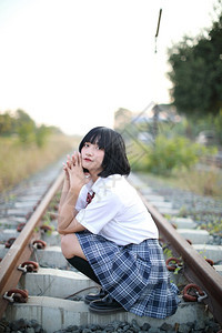 坐在铁路农村的亚洲女学生图片