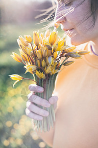 女孩拿着一束黄色野生郁金香花图片