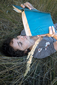 快乐的微笑女孩躺在干草丛里书写着复古风格图片