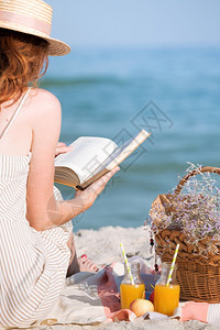 年轻女性在海边读书野餐图片