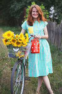 女孩骑着一辆旧自行车带一篮向日葵倒退式村里夏天图片