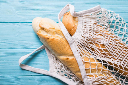 木制蓝底的法国袋式面包图片
