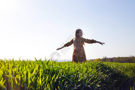 快乐的女孩在绿地上欢乐旋转夏天和自由图片