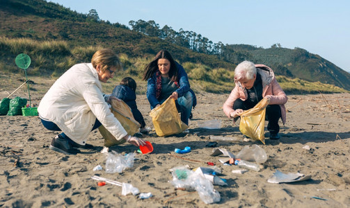 一群在海滩上捡垃圾的女志愿者图片