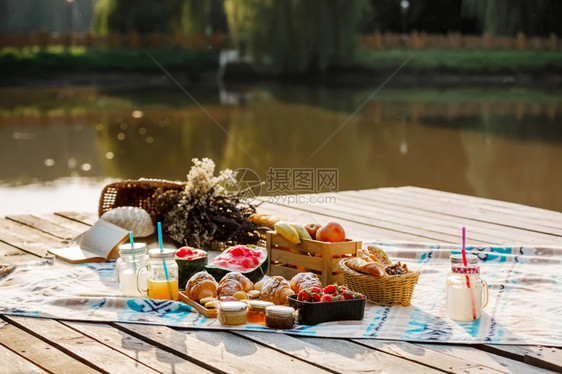 在湖附近的公园野餐新鲜水果冰冷的火花饮料和羊角面包在炎热的夏天野餐有选择午餐有选择焦点冰冷火花饮料和炎热的夏天羊角面包冰冷的火花图片