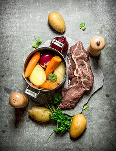 用蔬菜和肉煮汤在石头桌上用蔬菜和肉煮汤图片