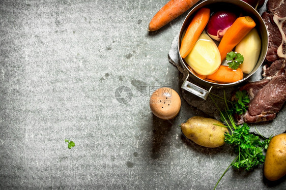 用蔬菜和肉煮汤在石头桌上用蔬菜和肉煮汤图片