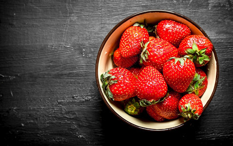 一碗熟的草莓在黑木桌一碗熟的草莓图片