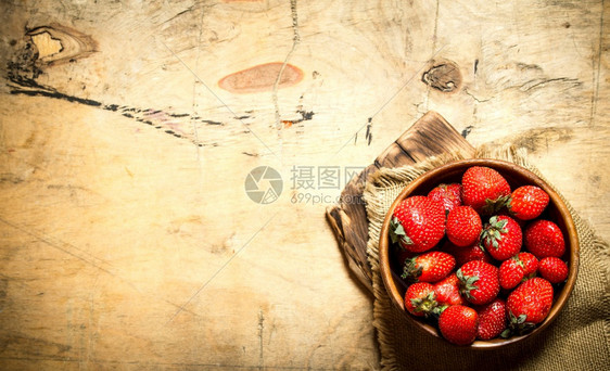 成熟的草莓在船上木质背景图片