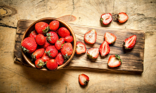 成熟的草莓在船上木质背景图片