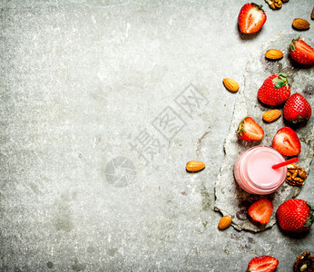 草莓冰淇淋加牛奶和坚果在石板上图片