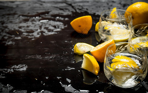 杯子加伏特和柠檬黑色木头背景图片