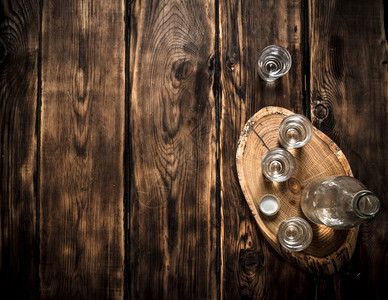 伏特加酒瓶上装着杯子 木制背景伏特加酒瓶上装着杯子图片