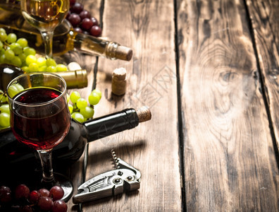 白葡萄和红的枝子放在木制桌上新鲜红酒和白图片
