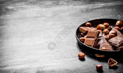 巧克力加坚果和肉桂黑木桌背景图片