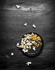 爆米花和玉在盘子上黑木板桌爆米花和玉在盘子上图片