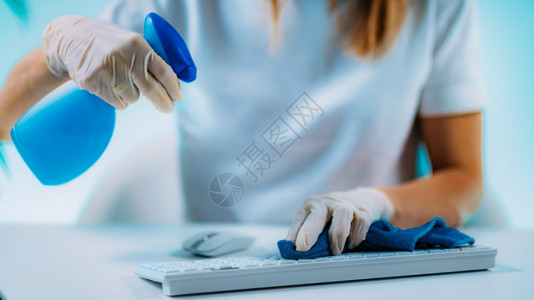 妇女用酒精消毒剂计算机键盘和老鼠消毒图片