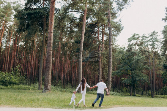 家庭父母收养和人的概念幸福的母亲父和小女孩在夏日公园散步玩得开心有选择地关注图片