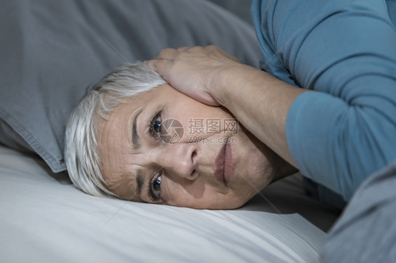 患有高血压或忧郁症的成年妇女晚上睡在床眠问题图片