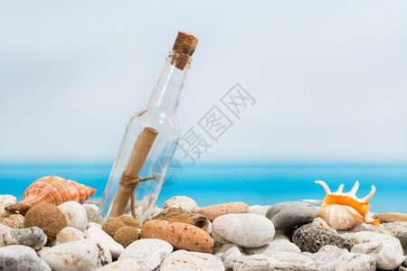 在沙滩上装满石头的瓶信息图片