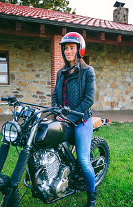 戴头盔的年轻女子在户外特制摩托车上骑头盔的妇女图片
