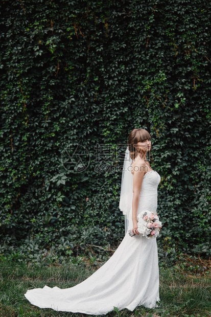 美丽的新娘穿着自然背景的时装婚纱美丽的年轻新娘令人难以置信的快乐图片