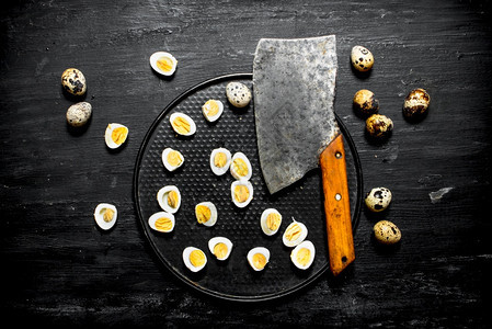 斧头和煮熟的鹌鹑蛋在盘子上图片