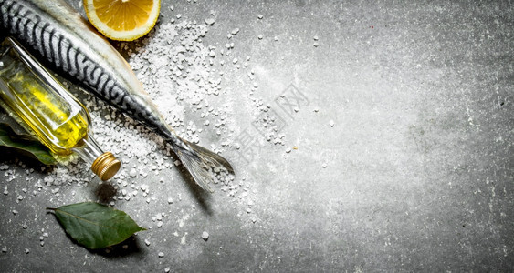 石桌上有橄榄油柠檬和盐的生鱼含橄榄油柠檬和盐的生鱼图片