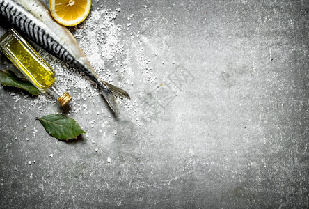 石桌上有橄榄油柠檬和盐的生鱼含橄榄油柠檬和盐的生鱼图片