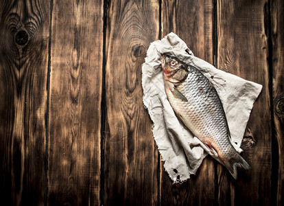 旧布料上的鲜鱼木质背景上的鲜鱼图片