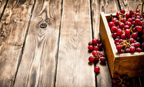 红葡萄在一个旧盒子里木本底图片
