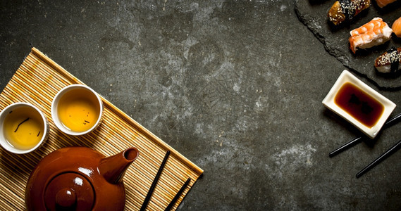 寿司加酱油和香茶在石桌上图片