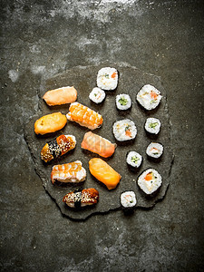 在石板上加金鱼虾鲑和卷子的寿司还有金鱼鲑和卷子的寿司图片