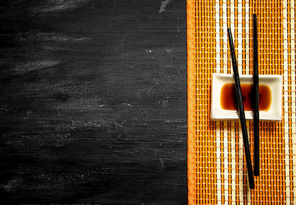 酱油和寿司的筷子黑木背景酱油和寿司的筷子图片