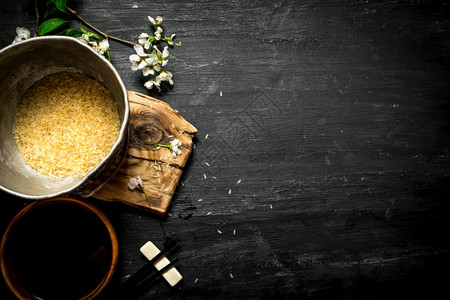 黑木背景的米和酱油黑锅的米图片