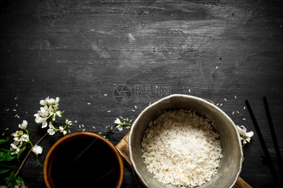 黑木背景的米和酱油黑锅的米图片