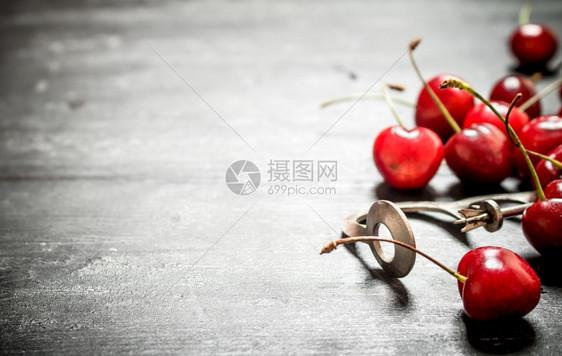 红樱桃带金属工具黑木背景带金属工具图片