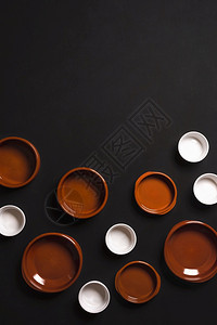 上方视图黑色背景上的空陶瓷盘白锅最高视图图片