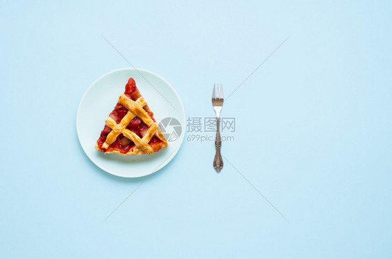 一块盘子上的胡巴和草莓馅饼切片以蓝背景隔离一块德国的胡巴蛋糕平原吃馅饼的概念图片