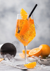 用橙子和调酒机匙鸡尾搅拌机在浅色桌底背景冰块和黑草图片