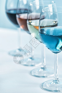 葡萄酒的选择桌上放着四只酒杯配着不同的葡萄酒红玫瑰白蓝葡萄酒葡萄酒品种桌上有四杯酒红酒玫瑰白葡萄酒和蓝葡萄酒背景图片