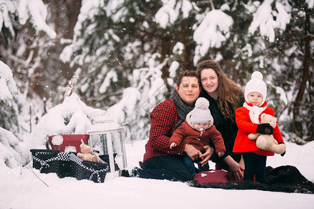 一个时髦的家庭在冬季森林里享受美好时光的肖像装饰着放松的地方装饰着放松的地方图片