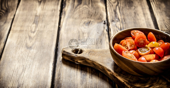 在木碗里切开新鲜的西红柿图片