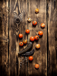 新鲜西红柿和一把旧刀木制背景图片