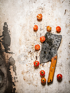 新鲜西红柿和一把旧刀生锈背景图片