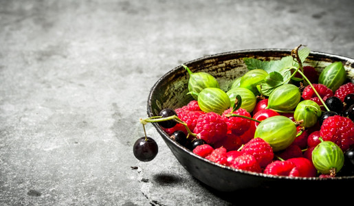 在老盘子里的野莓在石头桌上的野莓图片