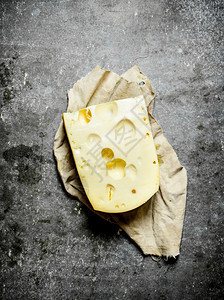 一块奶酪在旧纸上一块奶酪在石头桌上图片