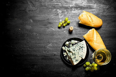 白葡萄酒蓝奶酪和西巴塔黑木本底图片