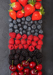 黑大理石板上色厨房桌底的大理石板上莓草蓝黑和樱桃图片